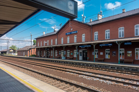 Navsi, Czechia - 06.17.2023: Empty train station with railroad tracks and brick station building on a nice day of summer. Traveling by train.