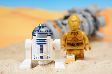 Fototapeta premium Lego Star Wars figures R2-D2 and C-3PO on the desert planet Tatooine after crash with rescue shuttle