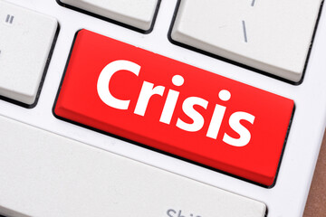 The red button on the keyboard with the word Crisis. Concept in business - difficult times for the economy around the world.