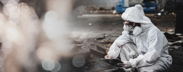 Workers wear protection suit checking chemical in old factory. Protecting Against Hazards and...