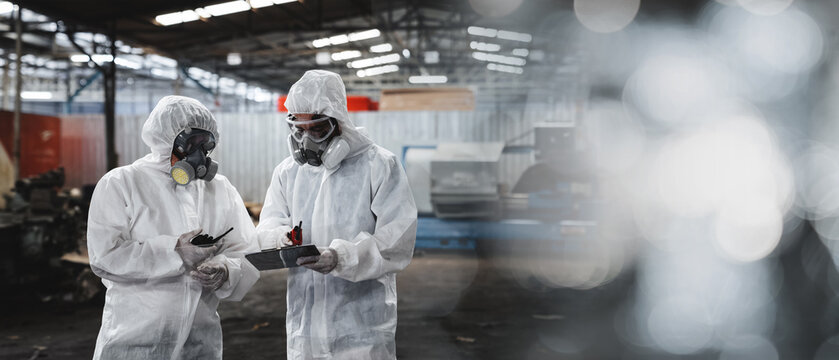 Workers wear protection suit checking chemical in old factory. Protecting Against Hazards and Contamination. Emergency Response to a Radioactive Accident.
