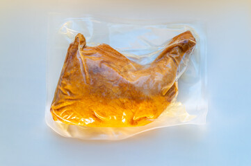 smoked chicken leg in vacuum packaging on the table