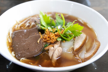Duck noodle soup on a white bowl.