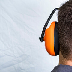Man wearing noise canceling headphones, hearing protection.	