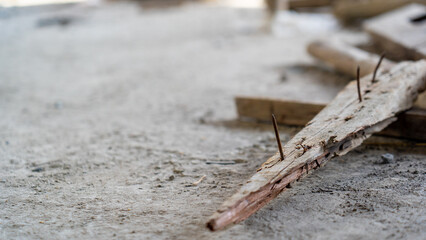 careless old rusty nail pierce in spiky timber wood, safety and risk concept of construction site...