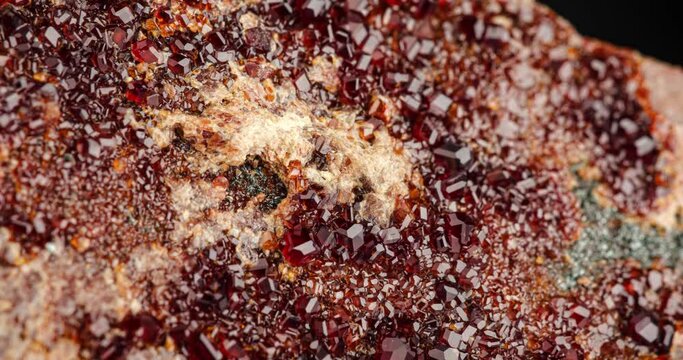 grossular (red garnet) cluster detail rotating in 4k. macro detail texture background. close-up raw rough unpolished semi-precious gemstone