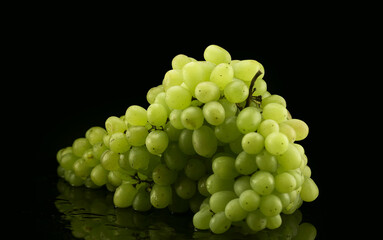 Big brunch of green grapes with drops of water on black background