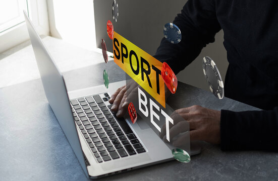 Man watching football play online broadcast on his laptop, cheering for his favourite team, making bets at bookmaker's website.