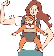 Strong mother with newborn in baby carrier shows biceps demonstrating confidence in future of child