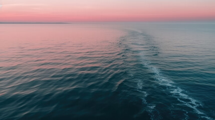 Soft pink horizon on a calm ocean surface.