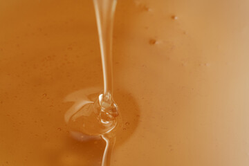 Closeup shot of organic honey pouring in bowl