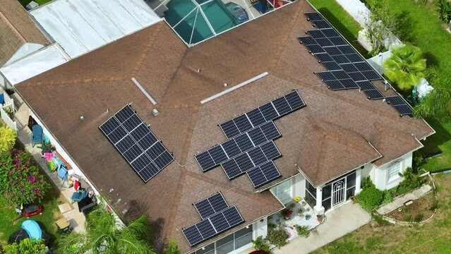 Aerial view of regular american home roof with blue solar photovoltaic panels for producing clean ecological electric energy. Renewable electricity with zero emission concept