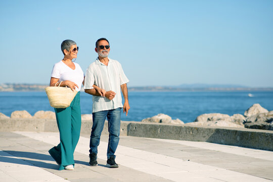 Senior Spouses Walking Along Promenade By Sea Outside, Free Space