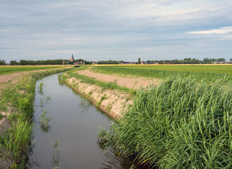 canal and fields in belgian province of west flanders