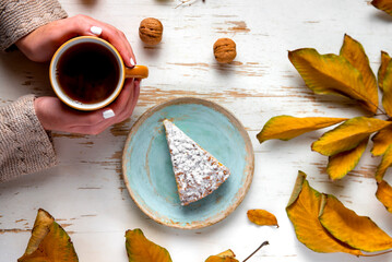 Baked pie served with hot tea on table with dried leaves and walnuts
