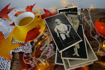old vintage monochrome photographs scattered on rustic wooden table, Autumn composition with hot...