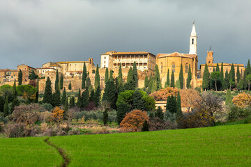 Fototapeta premium picturesque rolling hills of Tuscany are captured during a breathtaking sunset, with the sun's warm glow casting a golden light across the landscape. Vineyards and olive groves dot the hillsides.