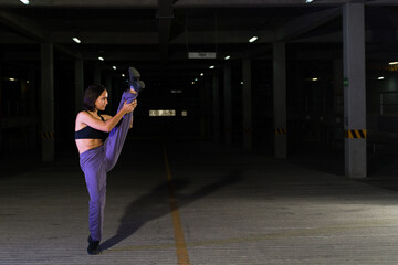 Artistic female street dancer dancing at night on an urban stage