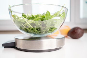 weigh food, diet and weight loss, salad in a bowl on a digital kitchen scales