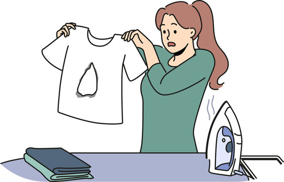 Clumsy housewife ironing clothes burnt hole in t-shirt and doesn know how to fix mistake