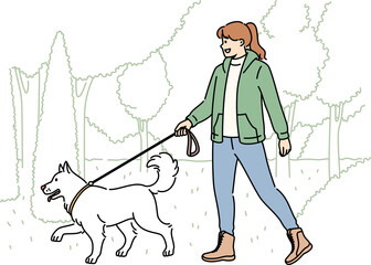 Smiling woman walking with dog in park