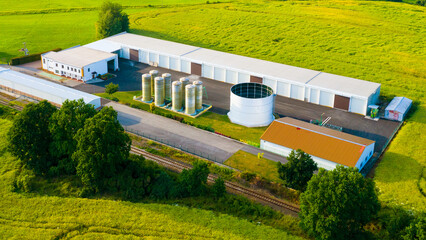 Fertilizer warehouse in the middle of green fields. Modern agriculture in the European Union from above. - 619080985
