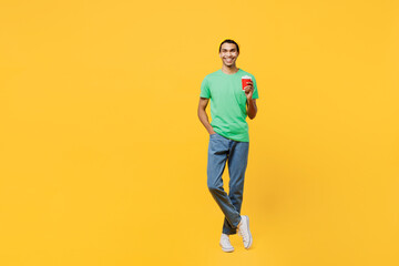 Fototapeta na wymiar Full body happy young man of African American ethnicity he wears casual clothes green t-shirt hat hold takeaway delivery craft paper brown cup coffee to go isolated on plain yellow background studio.
