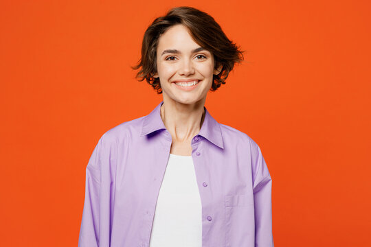 Young smiling happy fun cheerful cool satisfied caucasian woman she wear purple shirt white t-shirt casual clothes looking camera isolated on plain orange background studio portrait Lifestyle concept