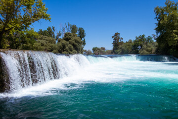 Manavgat waterfall Manavgat River is near the city of Side, 3 km north of Manavgat in Turkey. A wide stream of water falls from a low height.