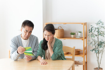 通帳を見るシニア夫婦