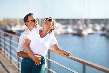 Romantic Senior Couple Embracing Expressing Happiness Standing At Marina Outside