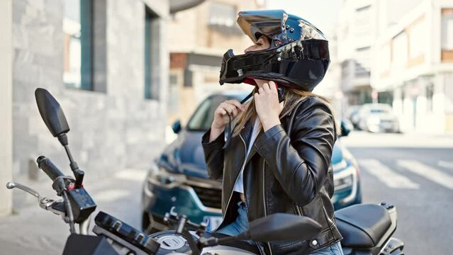 Young blonde woman wearing motorcycle helmet at street