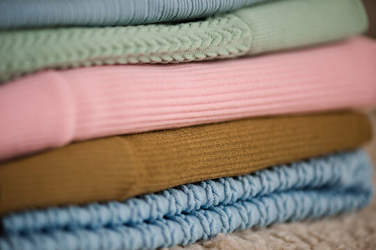 Stack of folded clothes and lingerie with ribbed fabric closeup. Selective focus.