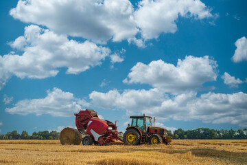 Red tractor makes hay bales © Mny-Jhee