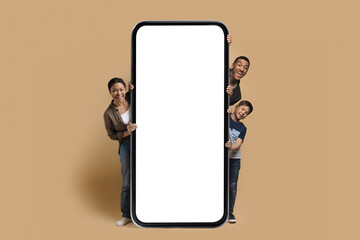Young black family posing by big white empty smartphone screen