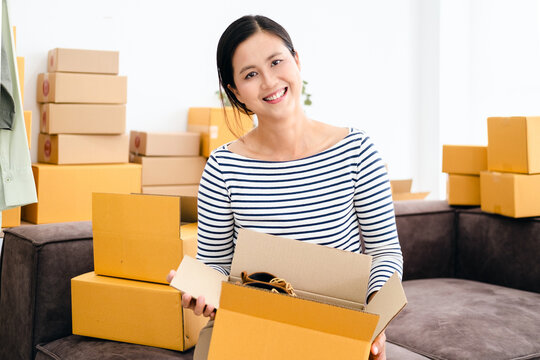 Start up small business entrepreneur SME or freelance woman working with box, Young Asian small business owner at home office, online marketing packing box delivery, SME teamwork moving house concept