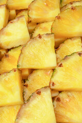 Pineapple juicy yellow slices as a background.