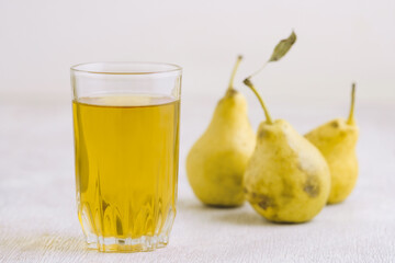 Juice of pears  in a glass on a white wooden background