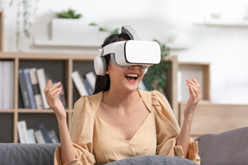 Asian lady wears VR headset having fun experience wearable virtual reality digital innovation technology happy moment. Excited and happy smiling girl watching through VR glasses. Smart device.