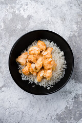 Rice with fried chicken fillet and almonds in a bowl, fresh lunch.