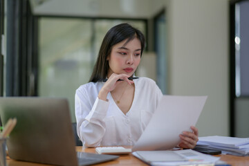 Young businesswoman working diligently, focus on working in front of the laptop. Analyze and plan new projects.