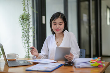Young businesswoman working diligently, focus on working in front of the laptop. Analyze and plan new projects.