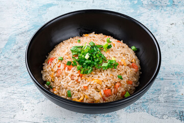 Fried rice with chicken, carrots, onions, soy sauce, sesame seeds and green onions, fresh lunch.