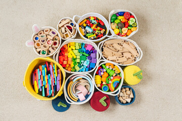 Colorful Toy Storage Baskets in the children's room. Cloth stylish Baskets with wooden toys. Organizing and Storage Ideas in nursery. Clean up toys and reduce the clutter. Top view