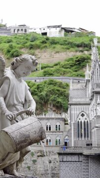 angel watering water near the mountains and the church of las lajas