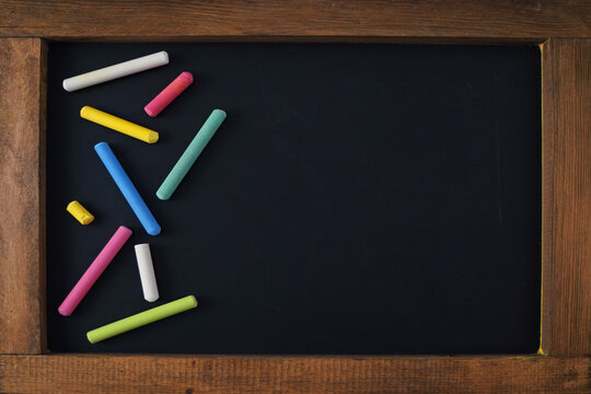 school board with chalk, chalkboard with wooden frame, colorful chalks on black background, 4k education wallpaper