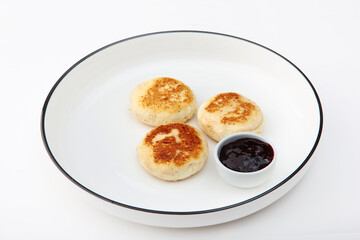 Cottage cheese pancakes or cheesecakes are served with jam. Healthy and delicious breakfast. Copy space. Isolated objects.White background.