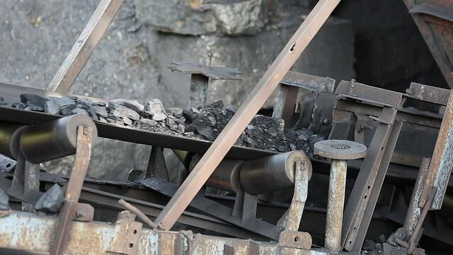 A video of roller belt conveyor machine transporting charcoal or bituminous coal