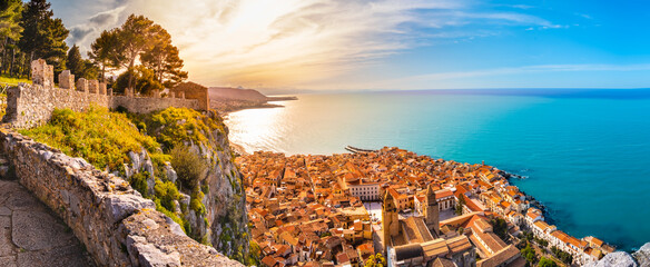 Aerial view of Cefalu at sunset. Medieval town on Sicily island, Italy. Seashore village with sandy beach, sea, historic buildings and mountains. Popular tourist attraction in Province of Palermo