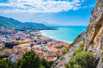 Fototapeta na wymiar Aerial view of Cefalu, medieval town on Sicily island, Italy. Seashore village with sandy beach, surrounted with mountains. Popular tourist attraction in Province of Palermo